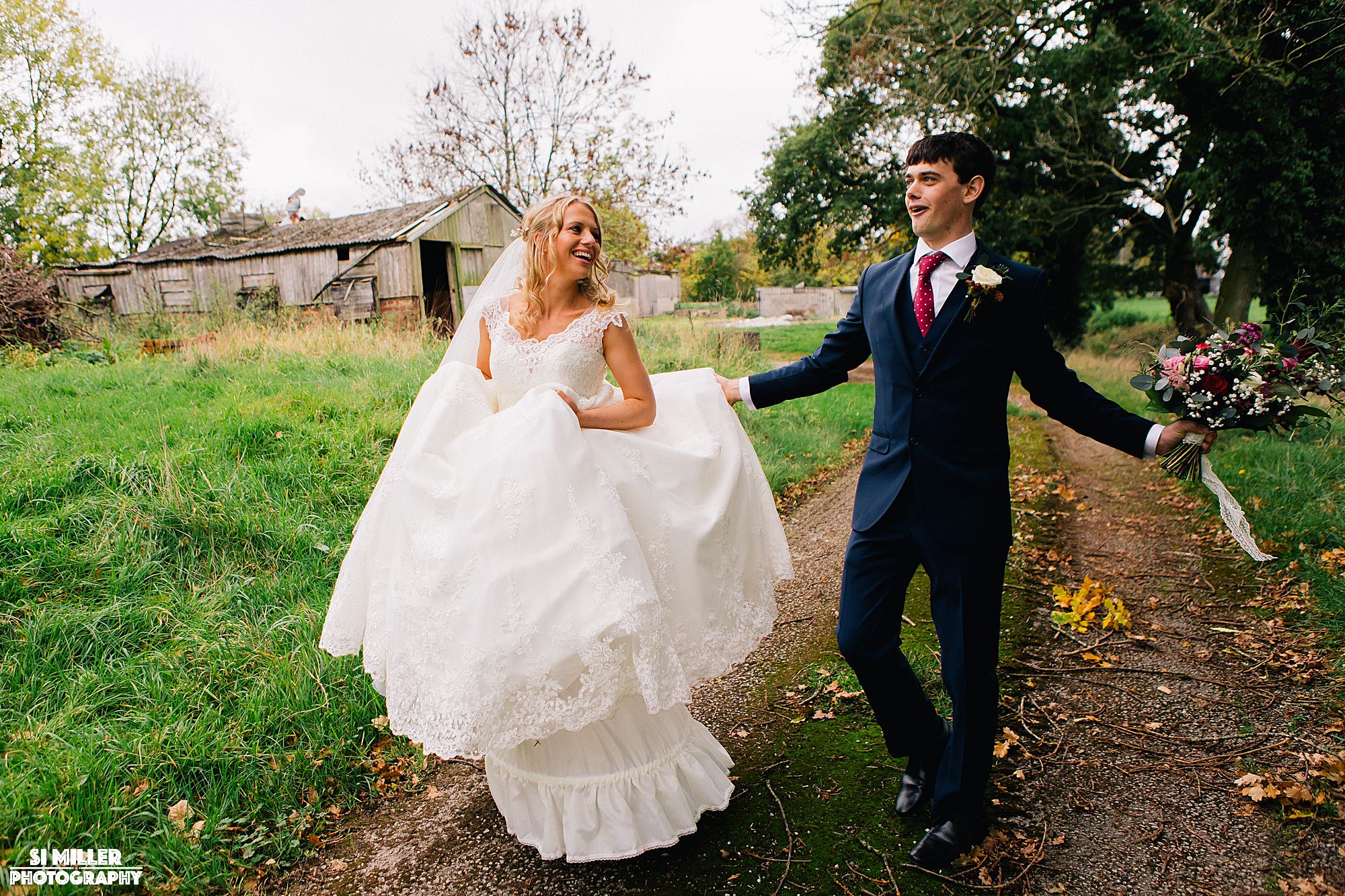 Bride and groom walking and laughing with boutique 