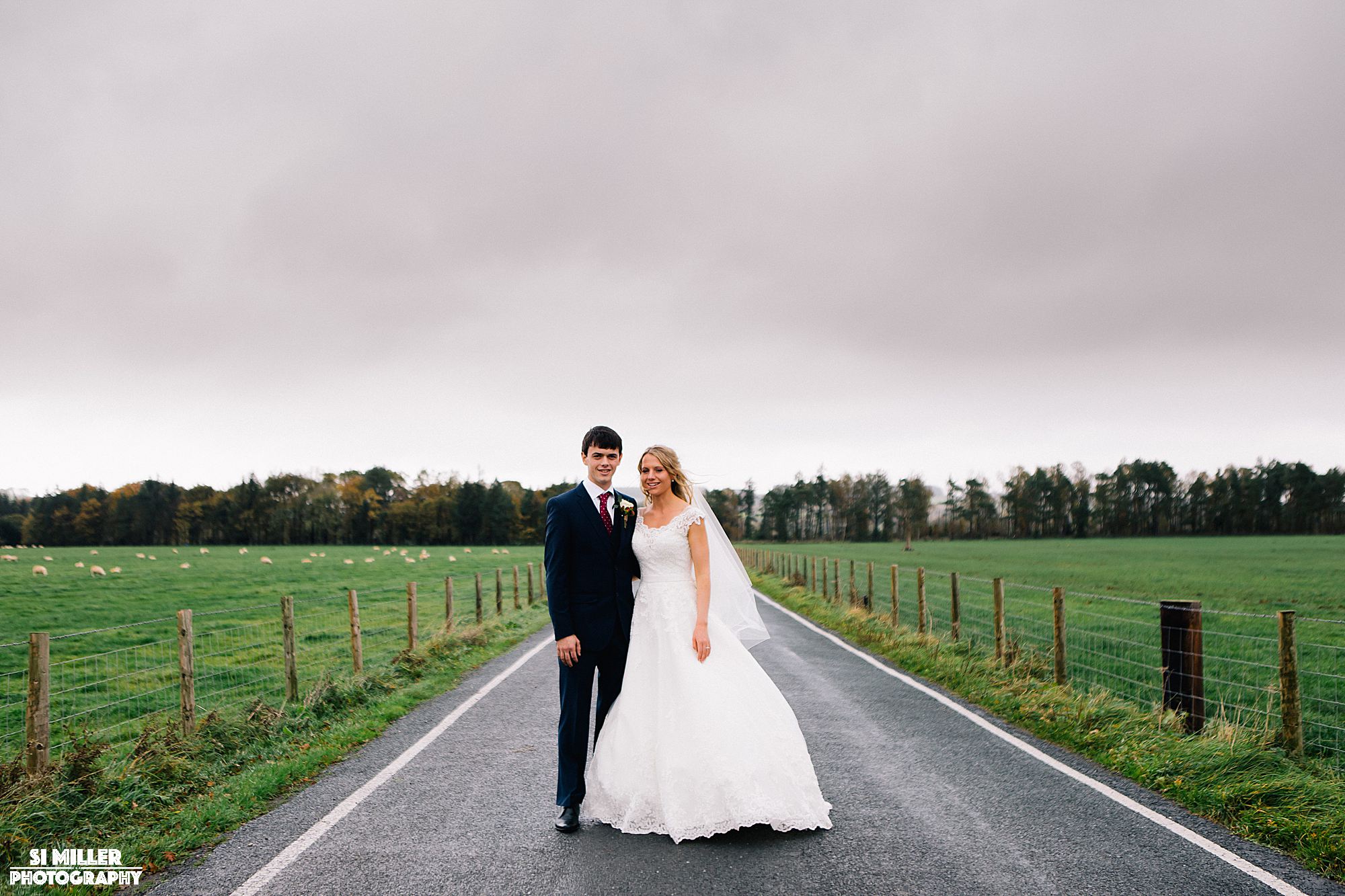 bride and groom on road leading to inn at whitewell 